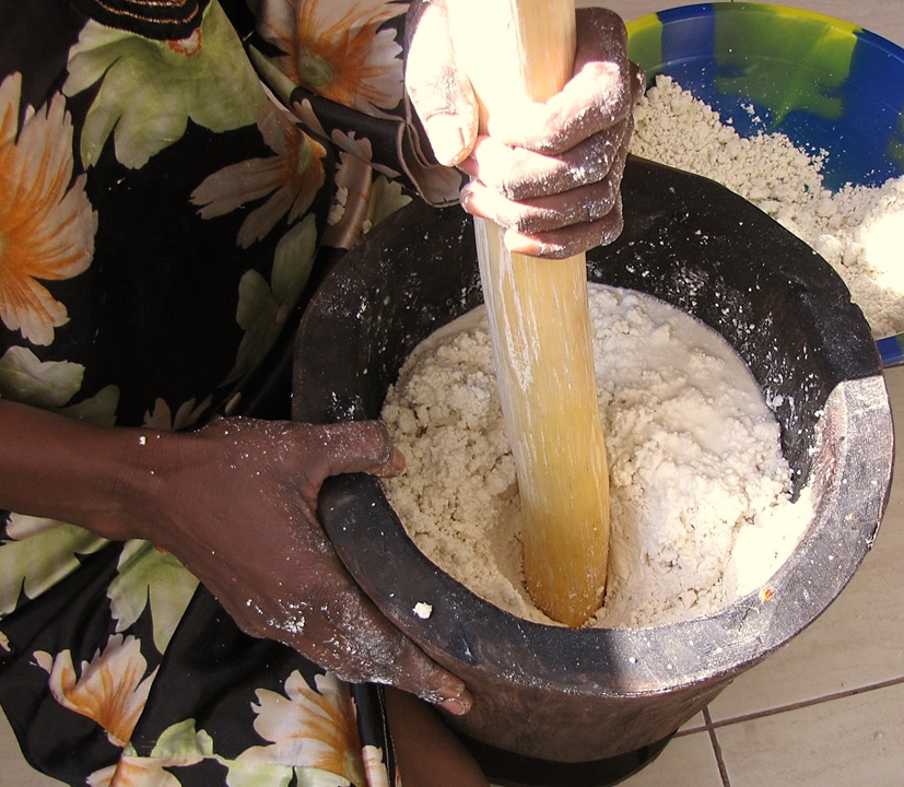 Hands kneading pizza dough on a floured surface